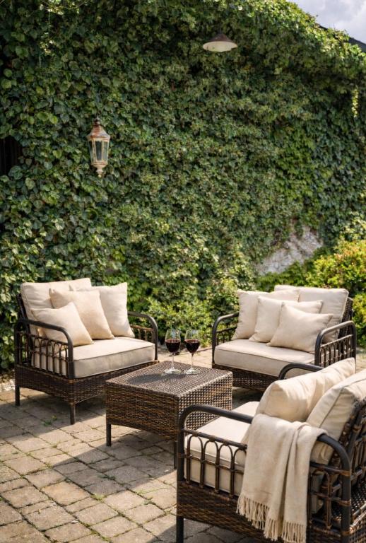 Cosy seating area in the garden, facing the ivy-covered wall of the villa