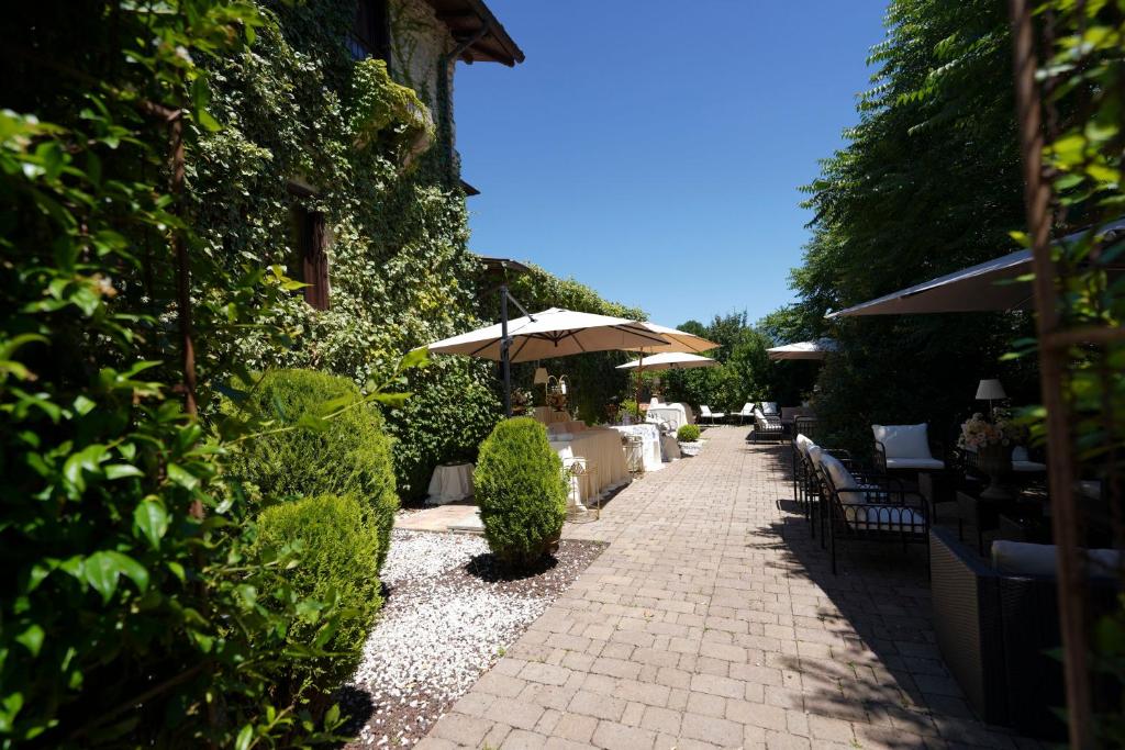 Stone courtyard at Villa Sant'Erasmo among hedges, parasols and outdoor seating areas