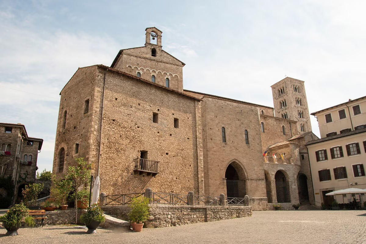 Exterior view of Anagni Cathedral, with its stone facade, Romanesque bell tower and paved square