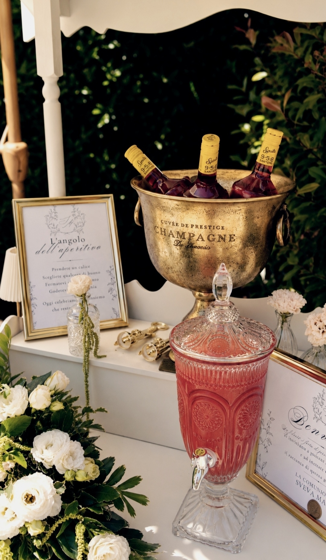 Drinks corner with beverages, white flowers and gold details in the garden of Villa Sant'Erasmo