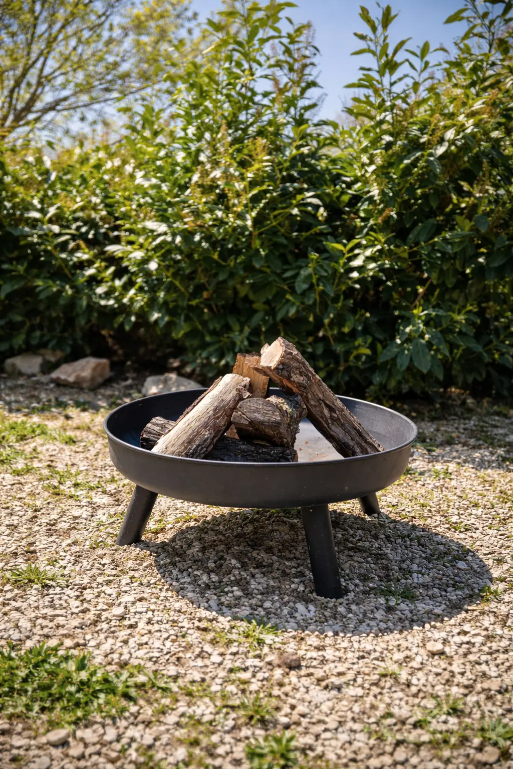 Brazier in the garden among gravel and evergreen hedges