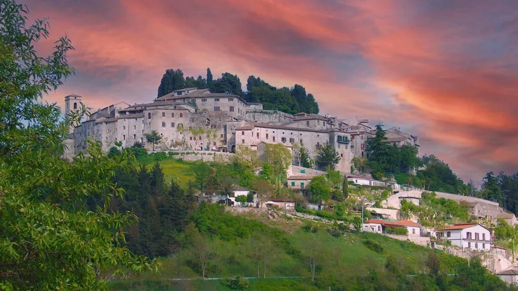 The village of Fumone perched on its hill at sunset, with a rosy sky above the stone houses