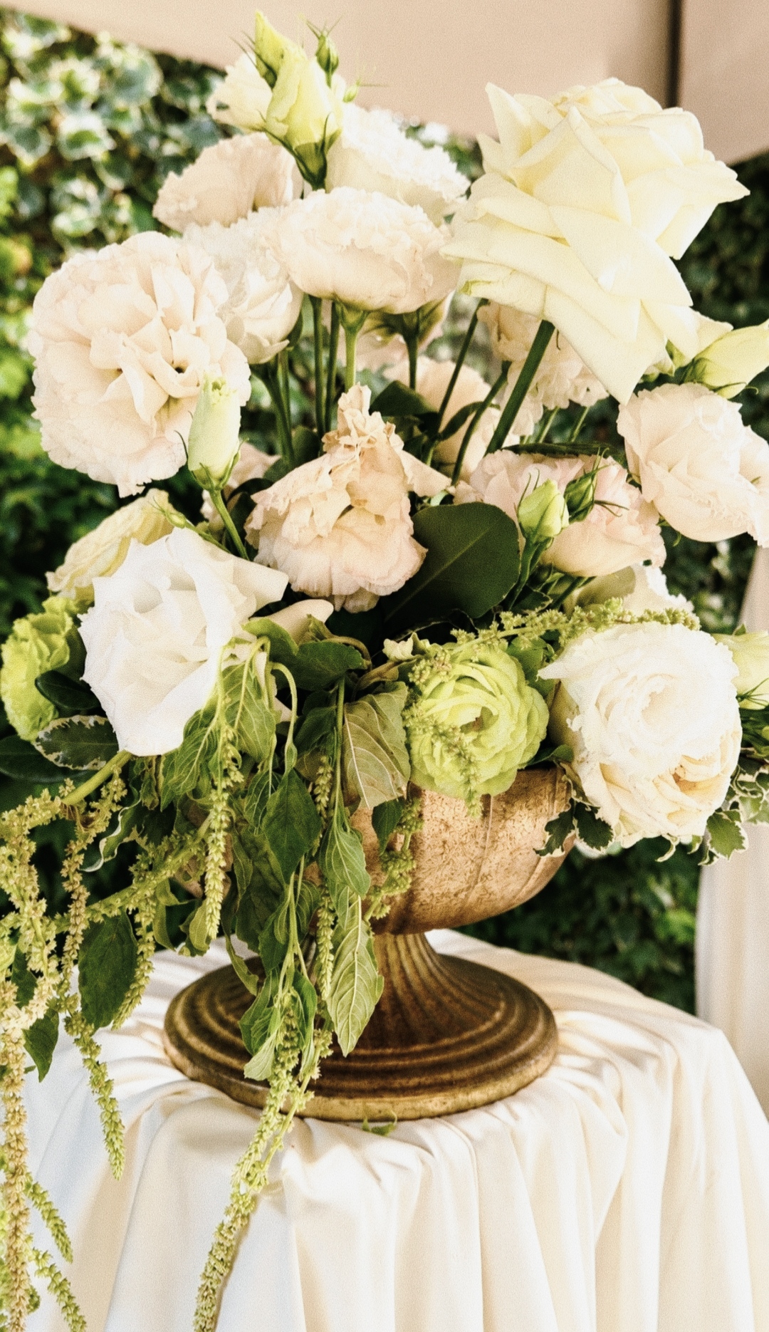Arrangement of white and green flowers in a gilded bowl