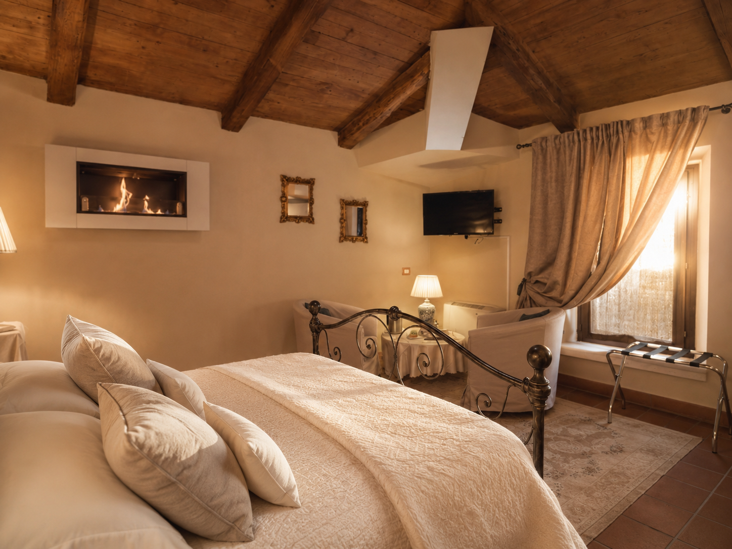 Room for the couple and guests at Villa Sant'Erasmo, with wooden beams, fireplace and wrought-iron bed